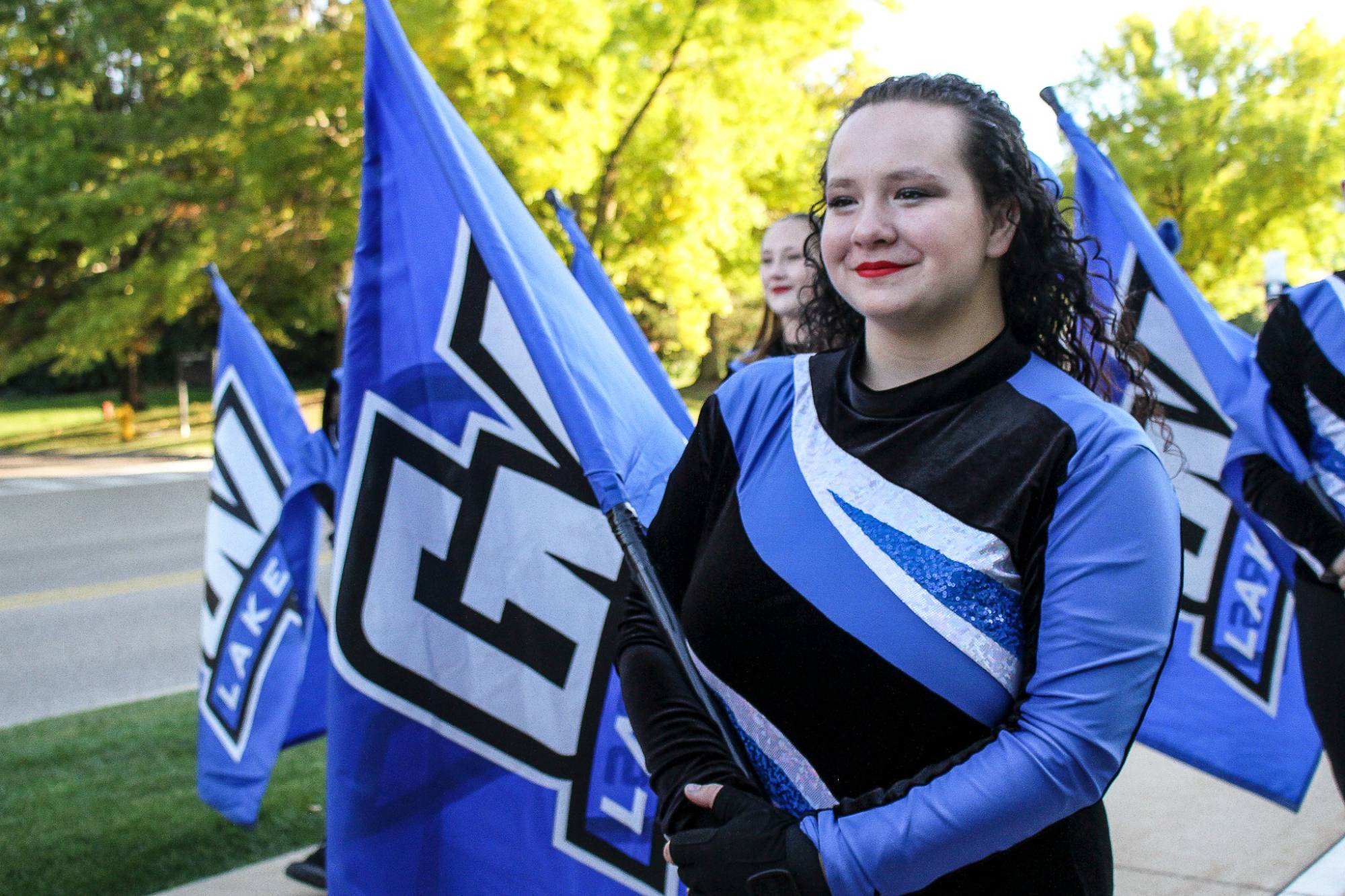 LMB Color Guard member holding their flag while marching down to Lubber's stadium on game day